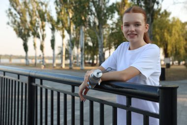 Açık hava eğitiminden sonra elinde su şişesi olan genç bir kız. Metin için boşluk