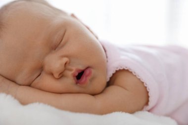 Yeni doğmuş şirin bebek evde yatakta uyuyor.
