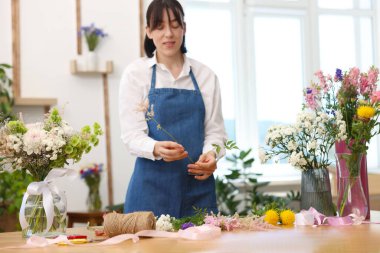 Çiçek buketi yapan çiçekçi.