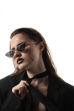 Siyah dudak kalemi olan güzel bir kadın beyaz arka planda ıslak güneş gözlüğü takıyor.