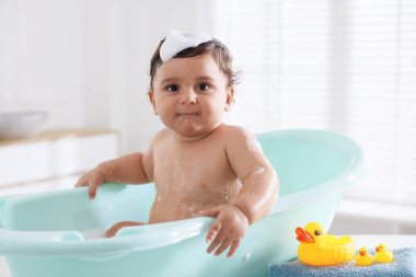 Evde küvette banyo yapan şirin bir bebek.