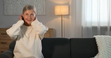 Evdeki kanepede son sınıf öğrencisi zarif bir kadın.