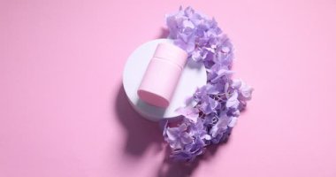 Kozmetik ürünlerin sunumu pembe arka planda çiçekler ve dumanla