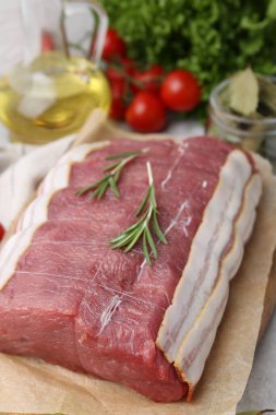 Bir parça çiğ et, domates ve baharatlar masada, yakın plan.