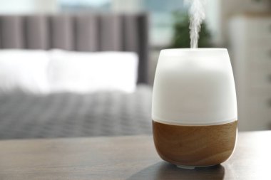 Ahşap masa üzerinde modern aroma lambası. Metin için boşluk