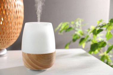 Beyaz ahşap masa üzerinde modern aroma lambası.