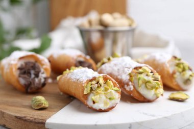 Ricotta peynirli, fıstıklı, çikolatalı ve pudra şekerli nefis cannoli. Arka planda bulanıklık var. Yakın plan.