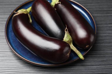 Pek çok olgun patlıcan siyah ahşap masada, yakın plan