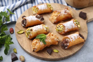 Peynirli, fındıklı, pudra şekerli, çikolatalı ve naneli nefis cannoli, yakın plan.