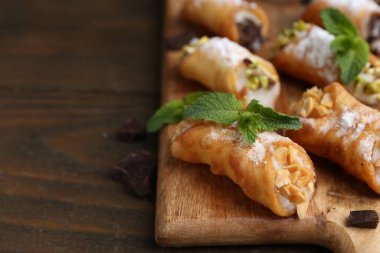 Peynirli, fındıklı, çikolatalı, naneli ve pudra şekerli nefis canoli, yakın plan. Metin için boşluk