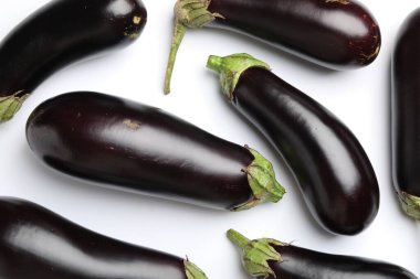 Beyaz arka planda bir sürü taze patlıcan var.