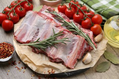 Taze et kaburgaları, domatesler ve baharatlar ahşap masada, yakın plan.