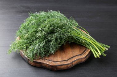 Siyah ahşap masada taze dereotu var, yakın plan.