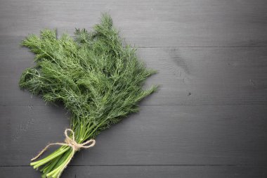 Siyah ahşap masanın üstünde taze dereotu var. Metin için boşluk