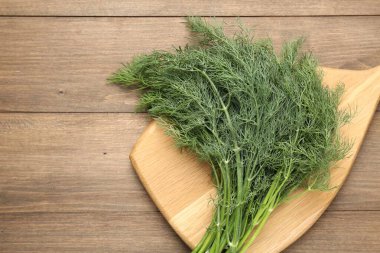 Ahşap masanın üstünde taze dereotları var. Metin için boşluk