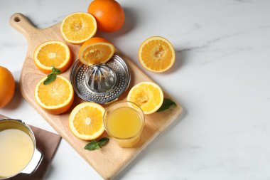 Portakallı sıkma, nane ve taze meyve suyu beyaz masada, düz yerde. Metin için boşluk