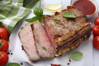 Lezzetli fırınlanmış et, domates, baharat ve üzerinde limon olan su.