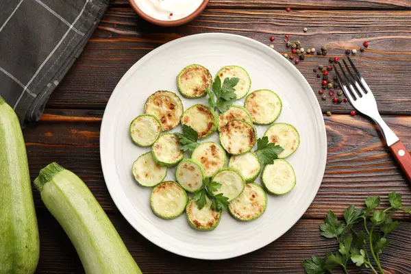 Tahta masada servis edilen maydanozlu lezzetli kızarmış kabak dilimleri.