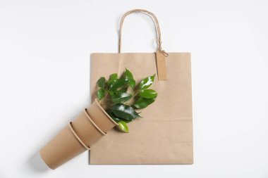 Çevre dostu ambalaj, fincanlar ve yapraklar beyaz arka planda, düz yatıyordu