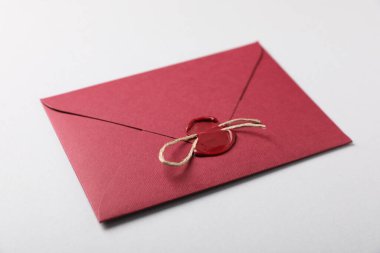 Beyaz arkaplanda balmumu mühür ve sicim olan zarf, yakın plan