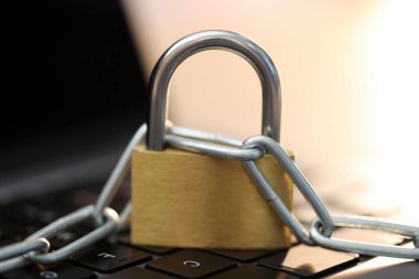 Siber güvenlik. Bilgisayarında zincir olan metal asma kilit, yakın plan.