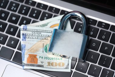 Siber güvenlik. Dizüstü bilgisayarda metal asma kilit ve dolar var.