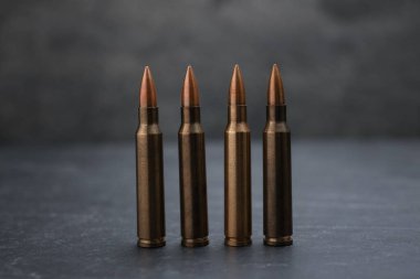 Gri masadaki ateşli silah fişekleri dumana karşı, yakın plan.