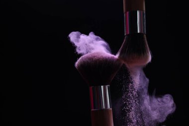 Siyah arka planda mor göz farlı makyaj fırçaları, yakın plan