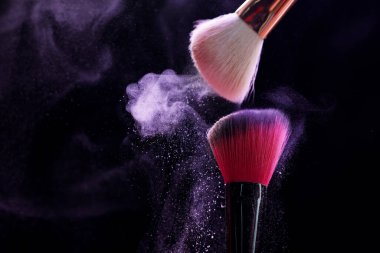 Siyah arka planda mor göz farlı makyaj fırçaları, yakın plan. Metin için boşluk