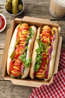 Sebzeli, hardallı, ketçaplı ve köpüklü sosisli sandviçler.