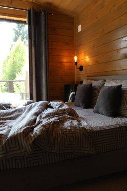 Otel odasının penceresinin yanında rahat bir yatak.