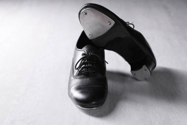 Beyaz tahta zeminde step dansı için bir çift ayakkabı.