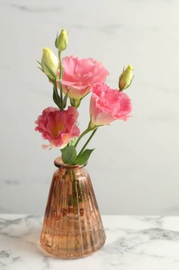 Beyaz mermer masada, cam vazoda güzel Eustoma çiçekleri, yakın plan