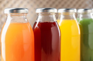 Cam şişelerdeki lezzetli sıvılar bulanık arka planda, yakın planda.