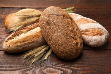 Tahta masada farklı ekmek ve buğday çivileri, yakın plan.