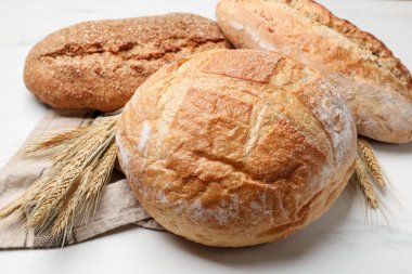 Beyaz mermer masada farklı ekmek ve buğday çivileri, yakın plan.