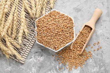 Kasede buğday taneleri, gri masada kepçeler ve çiviler, düz uzanmış