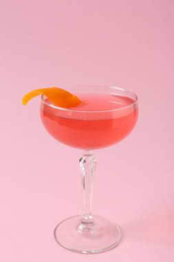 Pembe arka planda garnitürlü martini kokteyli, yakın plan.