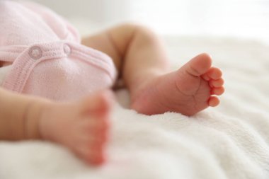 Sevimli yeni doğmuş bebek yatakta uzanıyor, yakın plan.