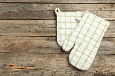 Fırın eldiveni ve tutacağı ahşap masada, üst tarafta. Metin için boşluk