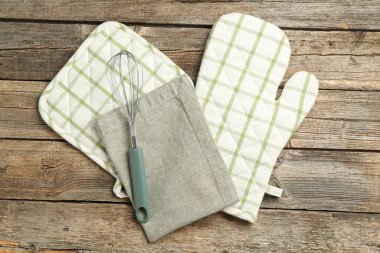 Fırın eldiveni ve diğer mutfak gereçleri ahşap masada, düz yatıyordu.