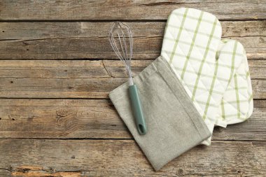 Fırın eldiveni ve diğer mutfak gereçleri ahşap masada, düz yerde. Metin için boşluk