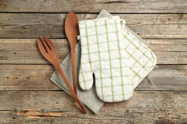 Fırın eldiveni ve diğer mutfak gereçleri ahşap masada, düz yatıyordu.