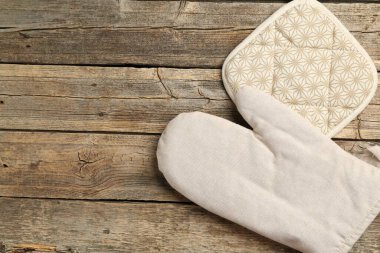 Fırın eldiveni ve tutacağı ahşap masada, düz yerde. Metin için boşluk