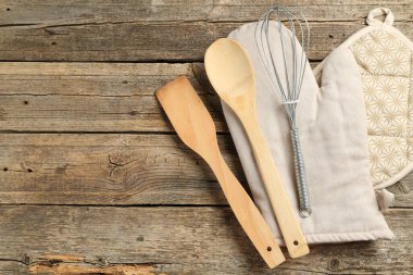Fırın eldiveni ve diğer mutfak gereçleri ahşap masada, düz yerde. Metin için boşluk