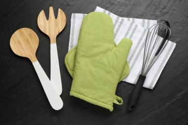 Yeşil fırın eldiveni ve diğer mutfak gereçleri koyu dokulu masa, düz yatıyordu.