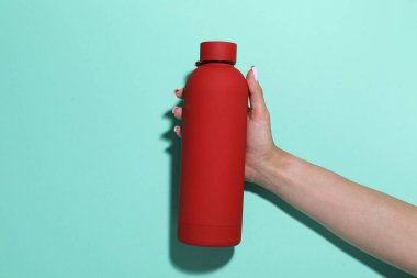 Turkuaz arka planda su şişesi olan kadın, yakın plan.