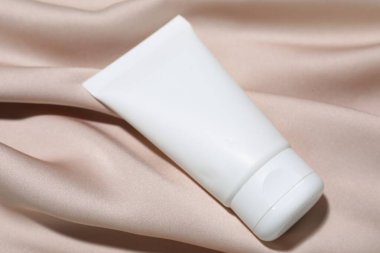 Bej kumaş üzerine kozmetik ürünler, yakın plan. Tasarım için model