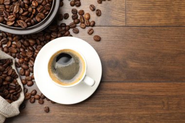 Aromatik kahve fincanda, fasulye de tahta masada, düz yerde. Metin için boşluk