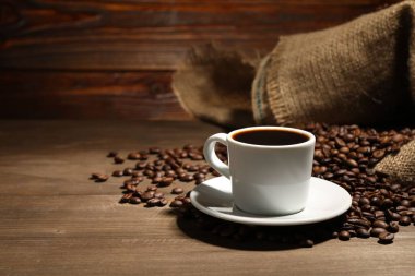 Aromatik kahve fincanda ve fasulye ahşap masada, metin için yer var.